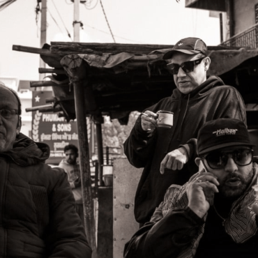 Pataka Boys in India with an elderly man, all looking straight into the camera.